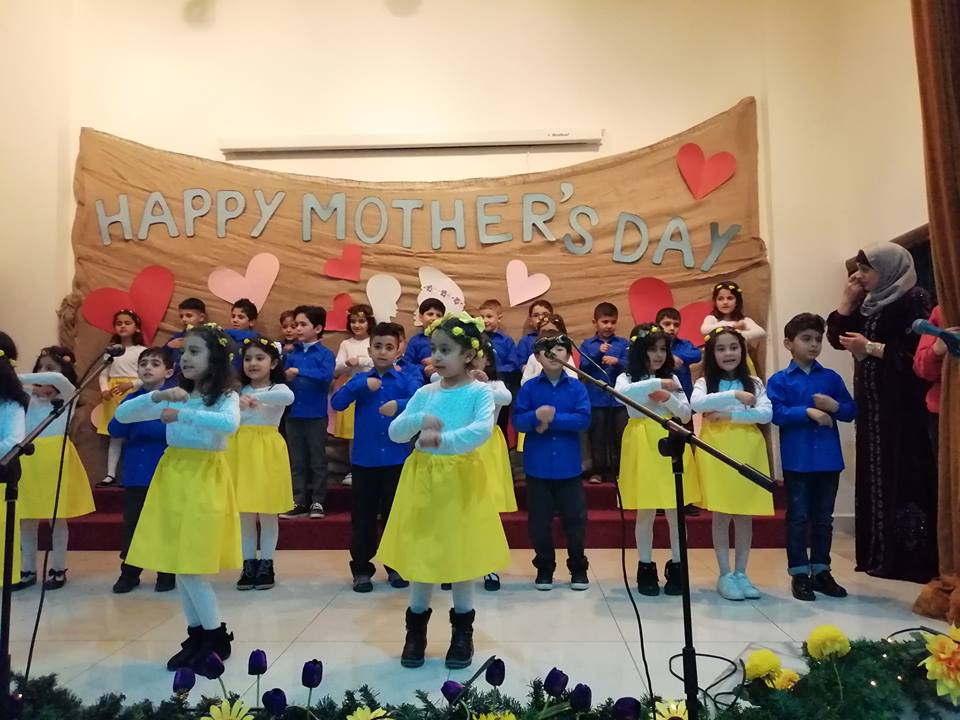 Students performing for the Mother's Day celebration at AES